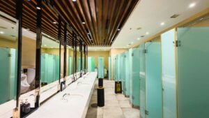 Modern public restroom with sinks, mirrors, and frosted glass stalls